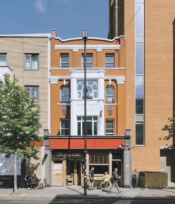 The front of 52 York Way: orange brick, white stucco and the arched fanlight window above the Lincoln Arms