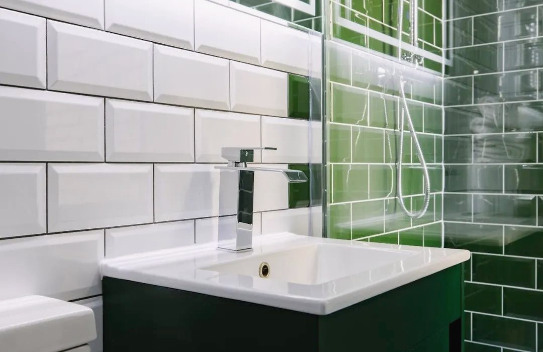 Basin and bottle-green tiles in the shower room