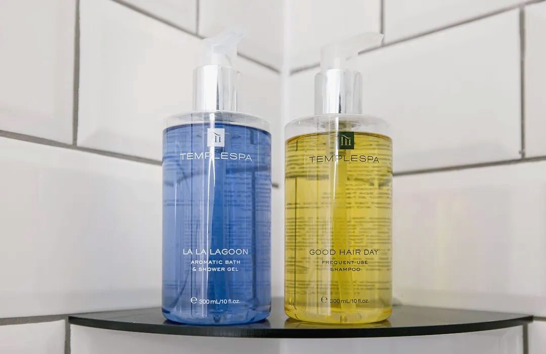 Shower gel and shampoo on a glass shelf