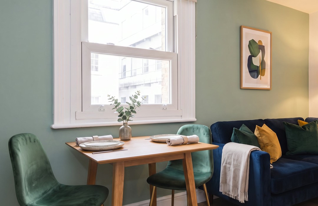 Round dining table by a sash window