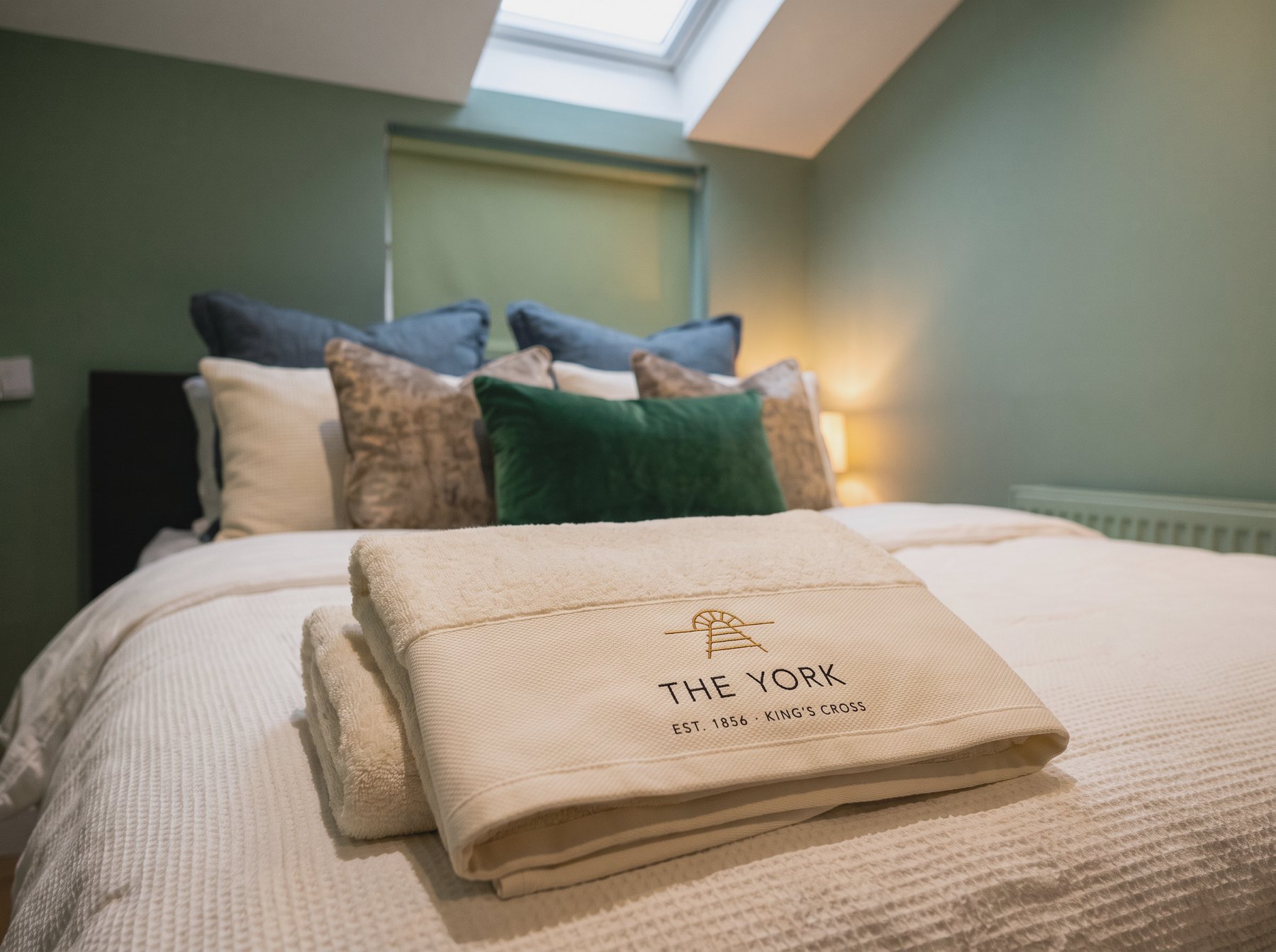 Towels embroidered with The York's mark, folded on the bed